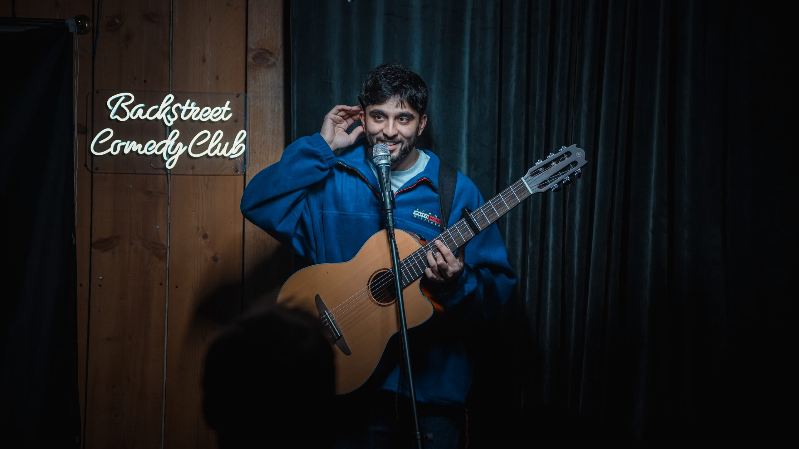 A performer with a guitar on stage