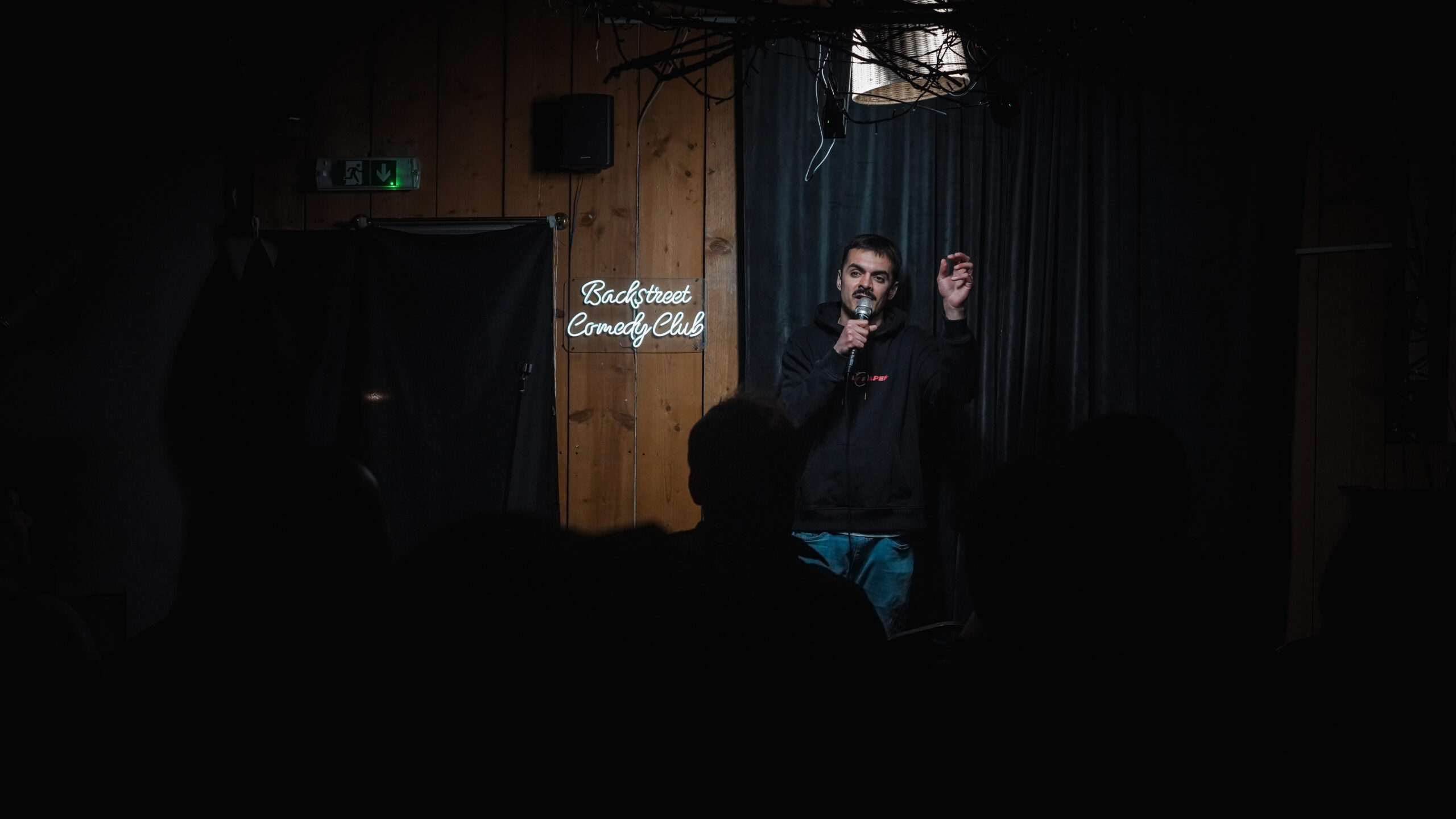 A comedian performing on the Backstreet Comedy Club stage